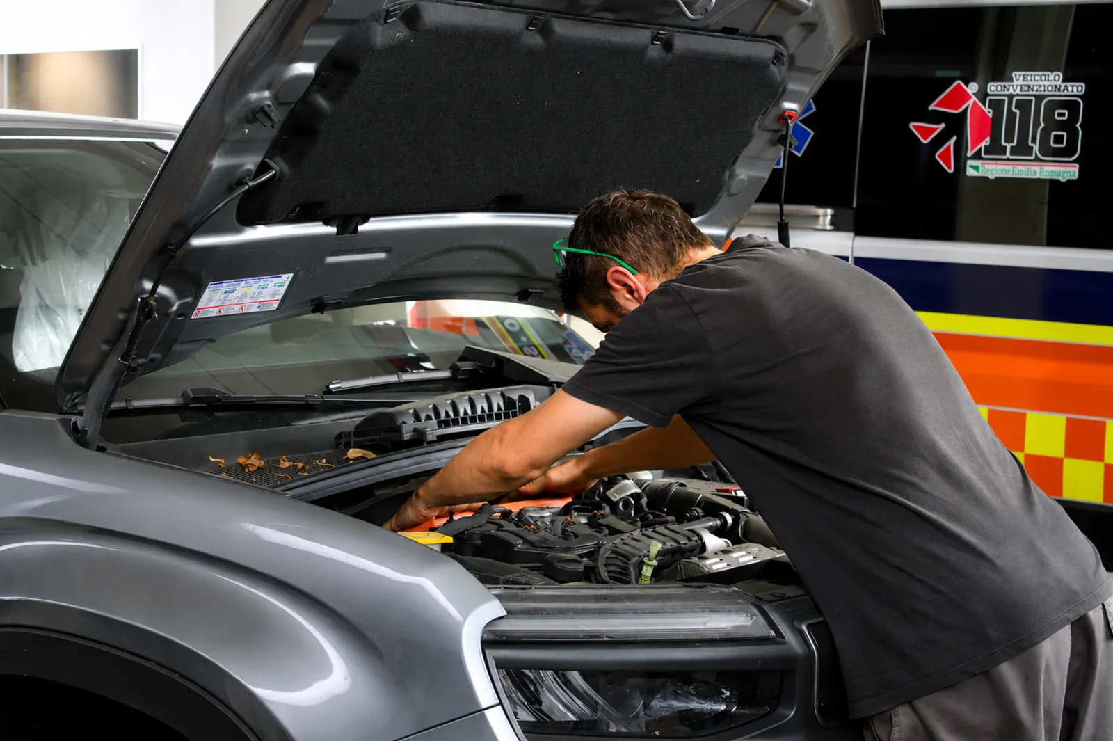 Meccanico al lavoro sul motore di un’auto in officina